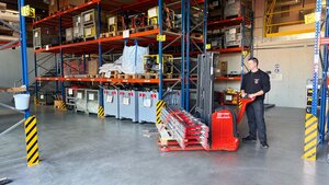 Bild vergr&ouml;&szlig;ern: Ein Mitarbeiter der Berufsfeuerwehr im Zentrallager des Gefahrenabwehrzentrum mit einem Elektro-Hubwagen.