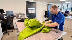 Bild vergr&ouml;&szlig;ern: Ein Gerätewart der in der Atemschutzwerkstatt des Gefahrenabwehrzentrum einen Chemikalienschutzanzug prüft.