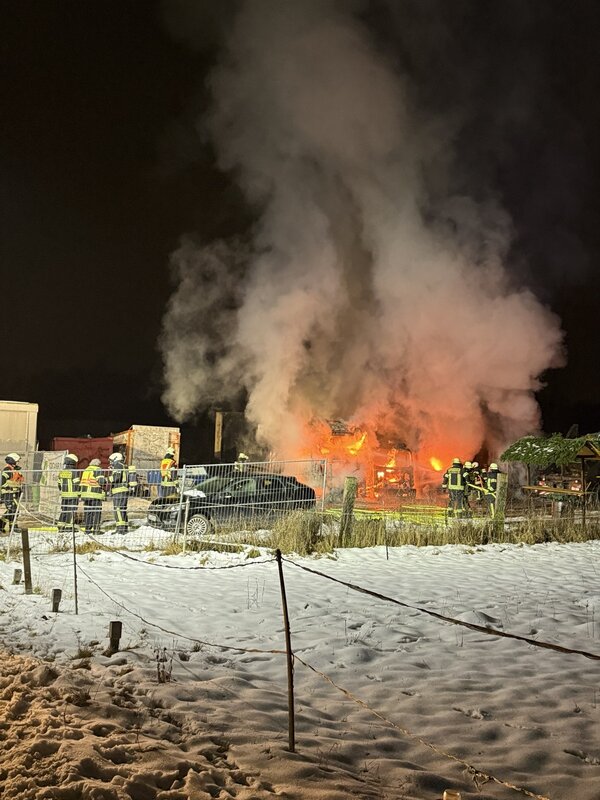 Feuerschein in der Ferne sichtbar, davor Einsatzkräfte.