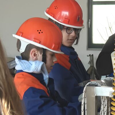 Bild vergr&ouml;&szlig;ern: Zwei Jugendliche machen Knoten an einem Gestell