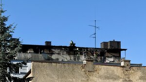 Einsatzkräfte auf einem ausgebrannten Balkon