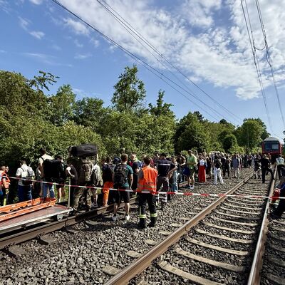 Bild vergr&ouml;&szlig;ern: Personen im Gleisbett, im Hintergrund ein stehender Zug