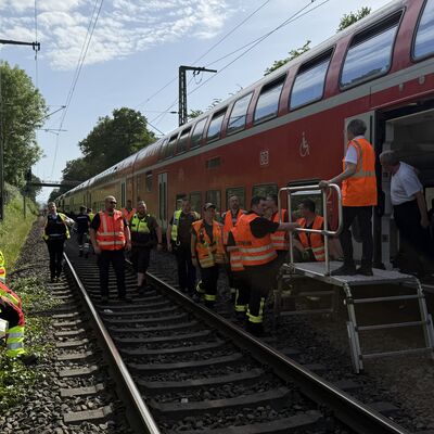 Bild vergr&ouml;&szlig;ern: Einsatzkräfte mit einer Rettungsplattform vor einem Zug