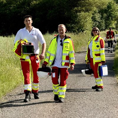Bild vergr&ouml;&szlig;ern: Einsatzkräfte des Rettungsdienstes auf einem Feldweg