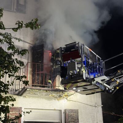 Bild vergr&ouml;&szlig;ern: Einsatzkraft auf einem Balkon im Löscheinsatz
