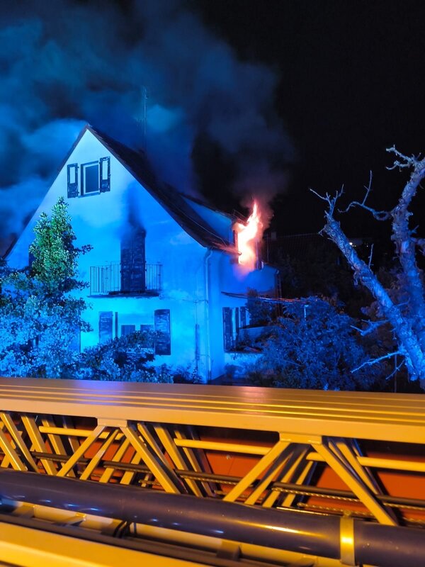 Wohngebäude, bei dem Flammen aus einem Fenster schlagen
