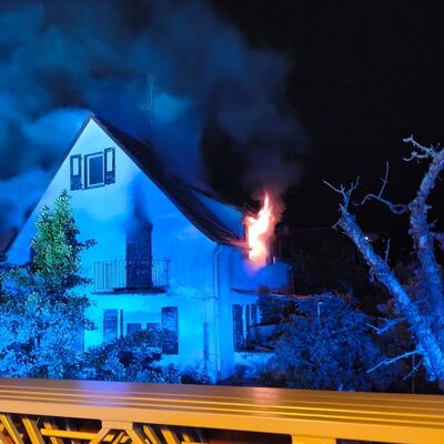 Bild vergr&ouml;&szlig;ern: Wohngebäude, bei dem Flammen aus einem Fenster schlagen