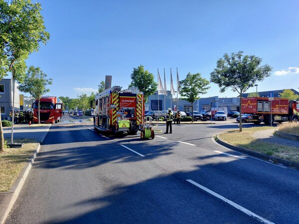 Mehrere Einsatzfahrzeuge auf einer Straßenkreuzung, im Hintergrund ein LKW, aus dem Flüssigkeit austritt