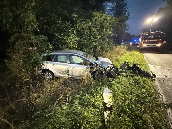 Verunfalltes Fahrzeug im Graben, im Hintergrund ein Löschfahrzeug der Feuerwehr