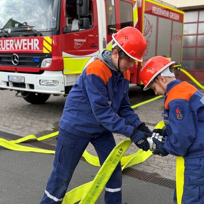 Bild vergr&ouml;&szlig;ern: Zwei Jugendfeuerwehrmitglieder beim Schlauchkuppeln