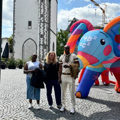 Bild vergr&ouml;&szlig;ern: Drei Personen vor einem aufblasbaren bunten Elefant.