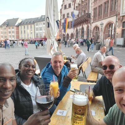 Bild vergr&ouml;&szlig;ern: Mehrere Personen mit Getränken auf einer Bierzeltgarnitur.