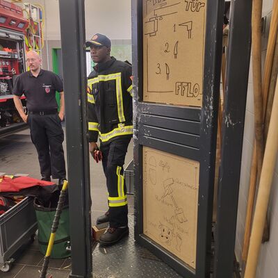 Bild vergr&ouml;&szlig;ern: Einsatzkräfte bei einer Ausbildung zur Türöffnung.