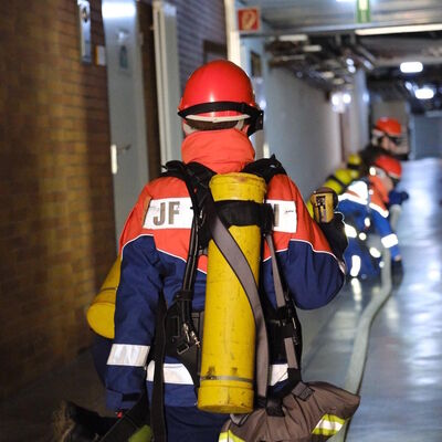 Bild vergr&ouml;&szlig;ern: Mitglieder der Jugendfeuerwehr bei einer Übung in einem Gebäude.