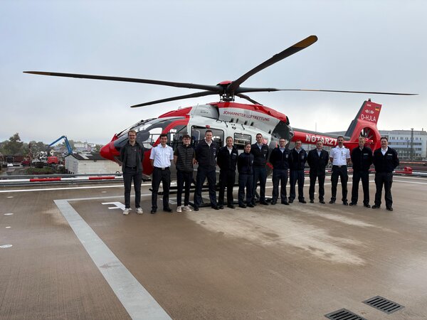 Bild vergr&ouml;&szlig;ern: 13 Personen vor dem Rettungshubschrauber Christoph Gießen