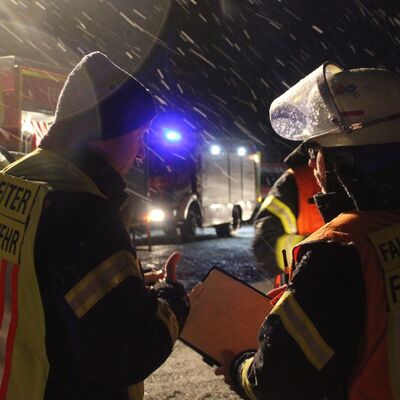Bild vergr&ouml;&szlig;ern: Einsatzkräfte bei Nacht im Schneefall