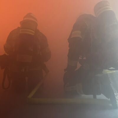 Bild vergr&ouml;&szlig;ern: Einsatzkräfte unter Atemschutz in verrauchtem Bereich