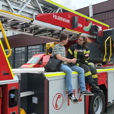 Bild vergr&ouml;&szlig;ern: Zwei Personen sitzend auf der Drehleiter