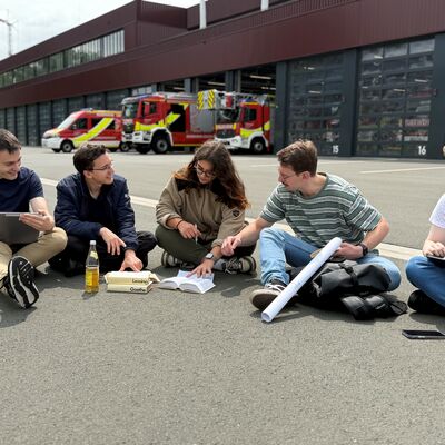 Bild vergr&ouml;&szlig;ern: Studierende sitzen vor Feuerwache