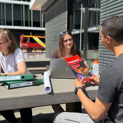 Bild vergr&ouml;&szlig;ern: Studierende vor Universitätsgebäude