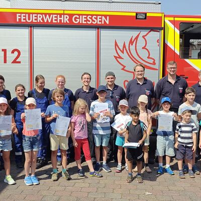 Bild vergr&ouml;&szlig;ern: Kinder mit Betreuer vor Löschfahrzeug