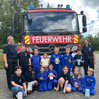 Bild vergr&ouml;&szlig;ern: Minifeuerwehr mit Betreuern vor einem Einsatzfahrzeug