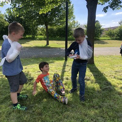 Bild vergr&ouml;&szlig;ern: Drei Kinder üben Verband anlegen