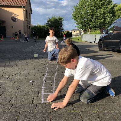 Bild vergr&ouml;&szlig;ern: Kinder zeichnen mit Kreide auf der Straße